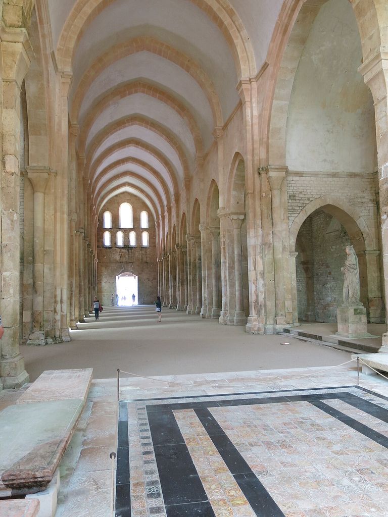 Repeated pointed transverse arches span a continuous high vault above substantial stone walls and supports.