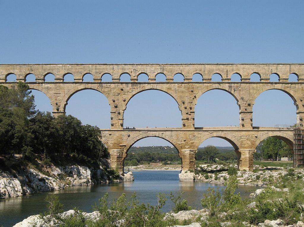 Large round arches support two further arcaded tiers across a river.