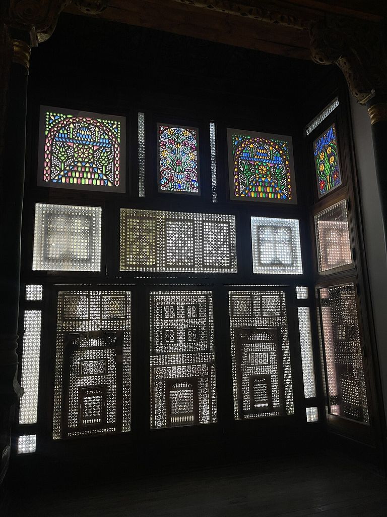 Intricate stained glass windows and wooden mashrabiyas (latticework screens) found within the Coptic Museum in Cairo, Egypt.