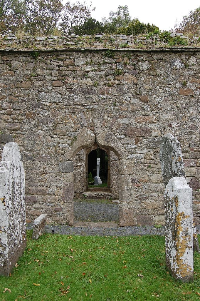 View through the Western of the doorways in the South wall at Kilfane Church towards the doorway in the Northern wall and the graveyard beyond, showing ogee arch doorway.