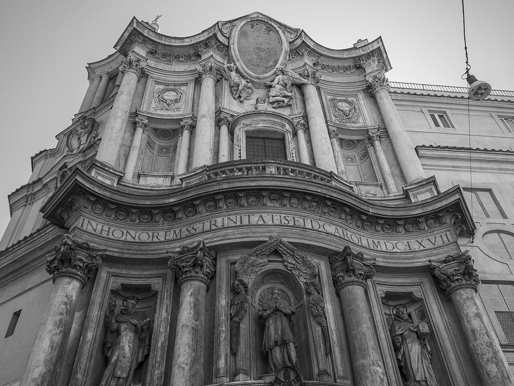 A richly carved church façade bends inward and outward around columns, curved cornices and interrupted frames.