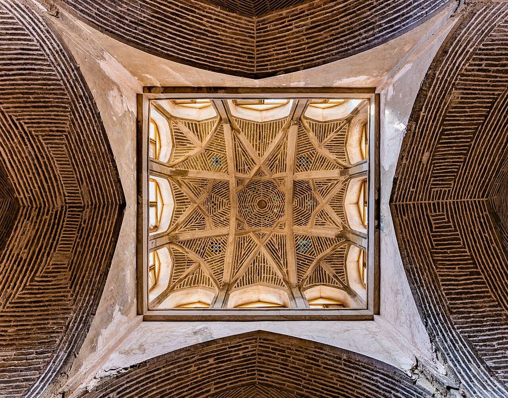 A square opening frames a star-like rib pattern and concentric brick courses within darker surrounding brick vaults.