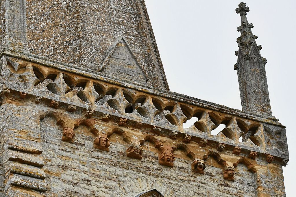 Trent, St. Andrew's Church, Tower parapet of pierced quatrefoils above head corbels - geograph.org.uk - 8136616, an architectural view.