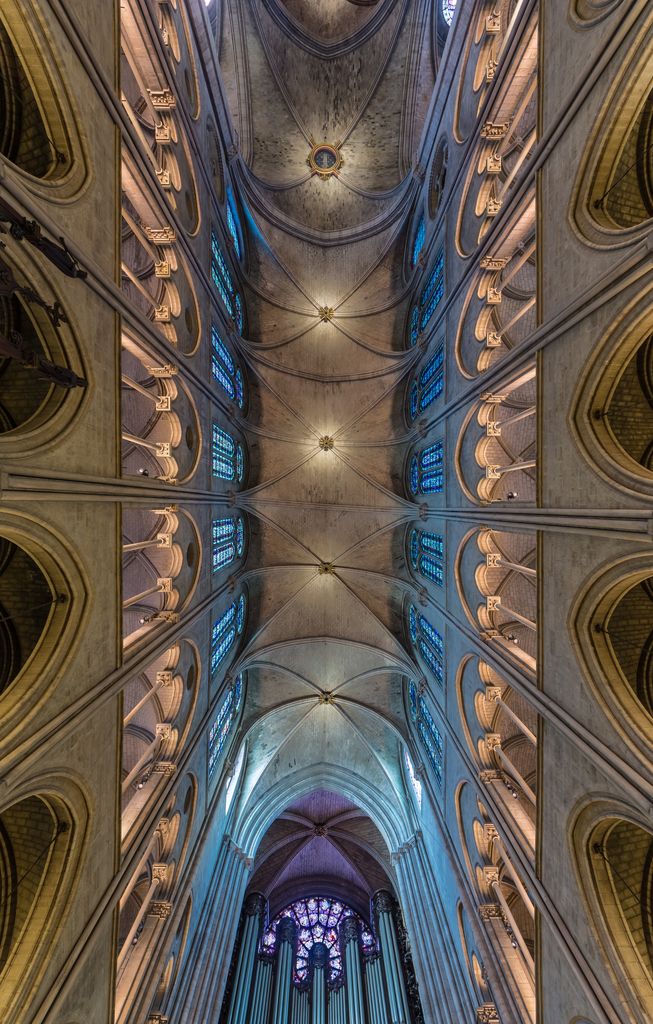 Several rib-vault bays recede overhead between clerestory windows, with transverse divisions, diagonal ribs and circular bosses clearly visible.