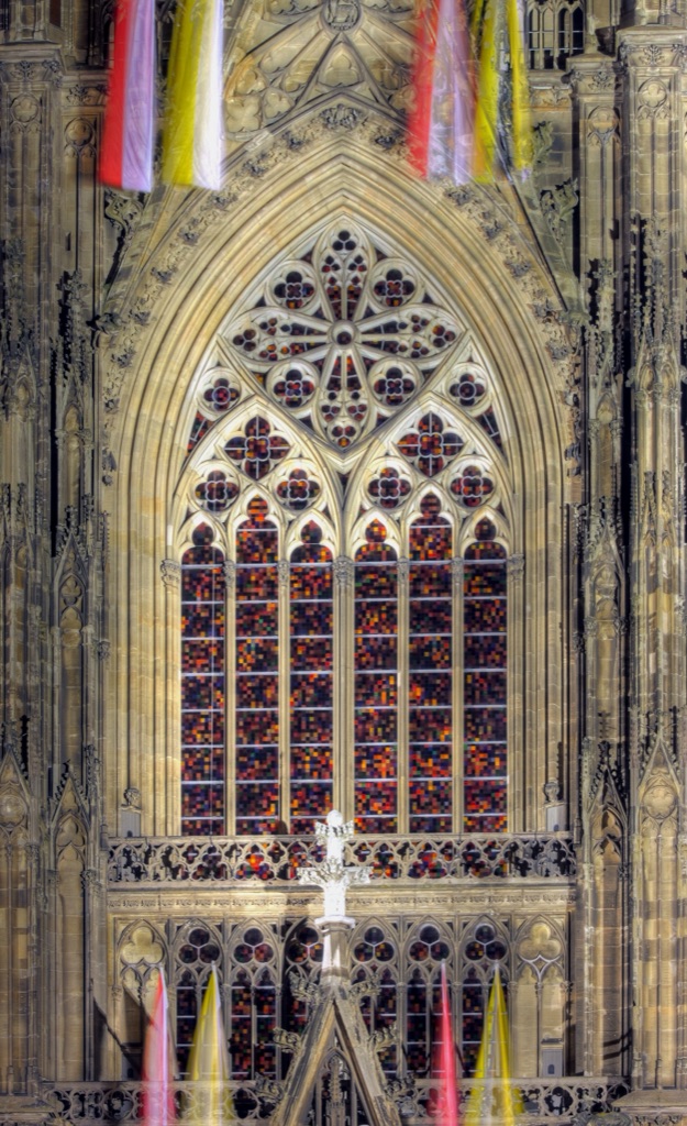 Gerhard Richter’s gridded coloured-glass window fills the Gothic tracery of Cologne Cathedral’s south transept, seen illuminated from outside at night.