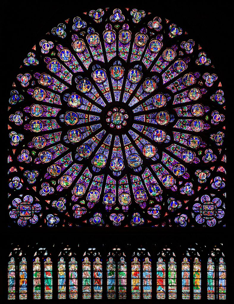 A large circular stained-glass rose glows with dense blue, red, green and gold figures above a row of tall coloured lancet windows against a dark interior.