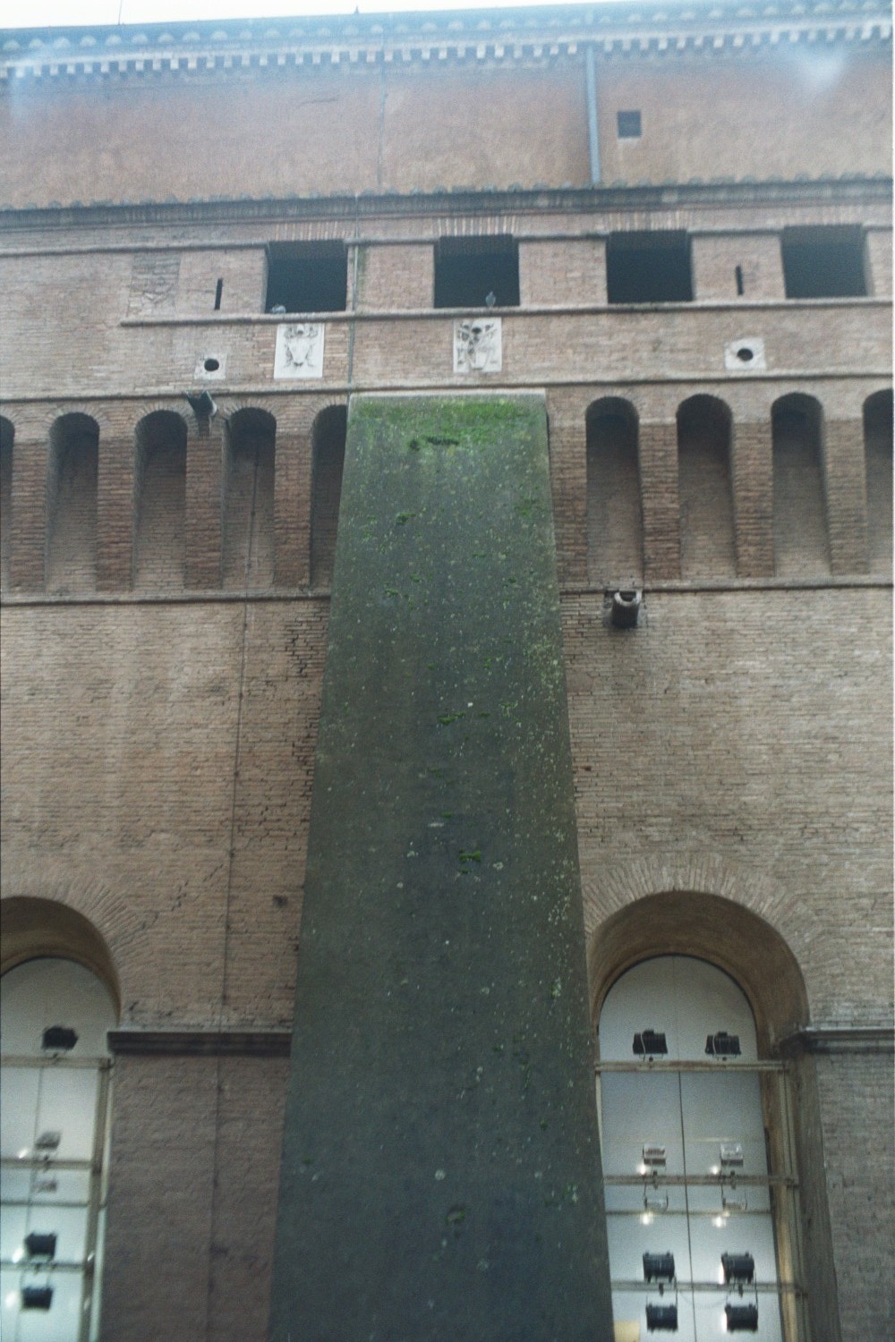 Exterior view of the Sistine Chapel’s tall brick north wall, round-headed windows, buttresses and roofline.