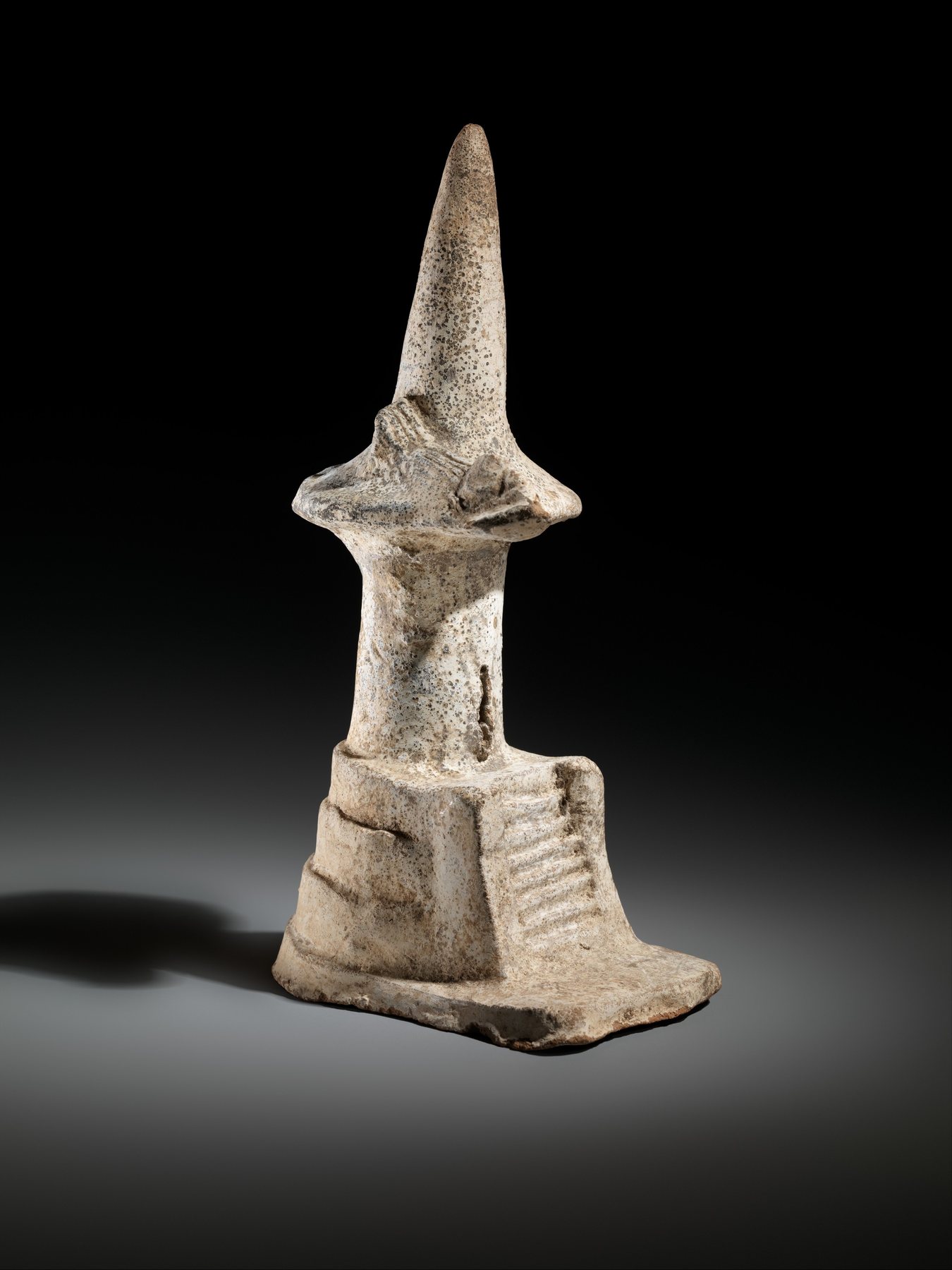 Mexica ceramic miniature temple with a tall tapering upper form and small stairway on a low stepped base.
