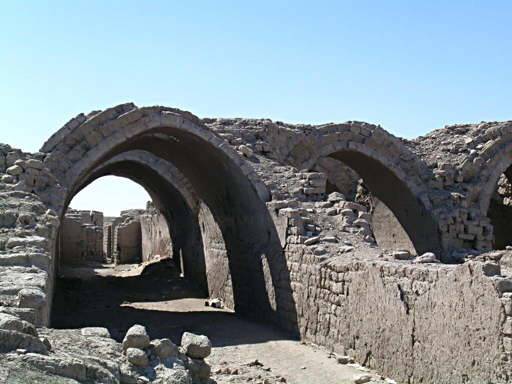 Partly ruined rows of mudbrick storage vaults with exposed brick courses and worn plaster at the Ramesseum.
