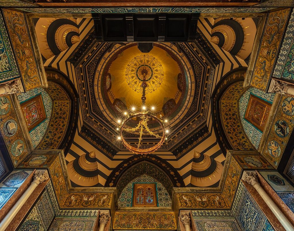A gilded dome rises above arches, columns and densely patterned tile and mosaic surfaces.