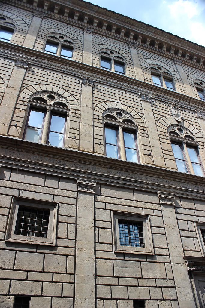 Three levels of rusticated masonry and paired windows divided by pilasters and horizontal entablatures.