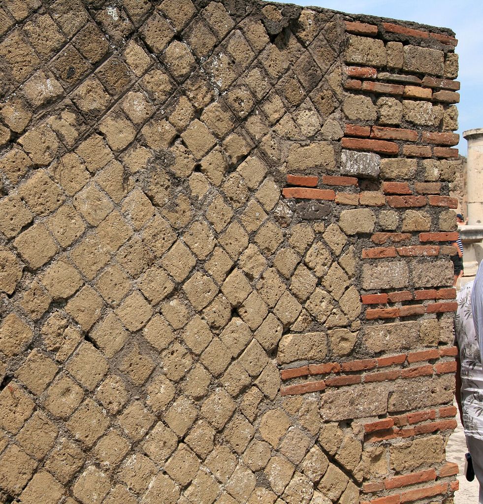 Diagonal stone units forming a net-like wall facing beside horizontal brick and stone bands at Pompeii.