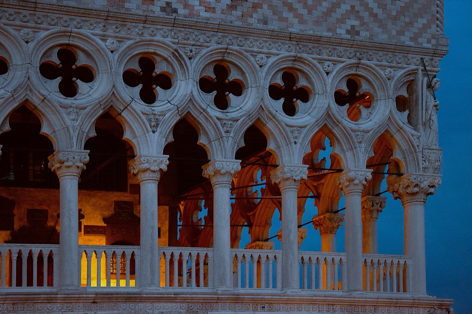 Evening close view of the Ducal Palace Venice upper loggia with recurring arches and varied capitals.