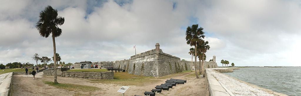 Low angular masonry defences, a bastion and cannon extend across a wide waterfront view.