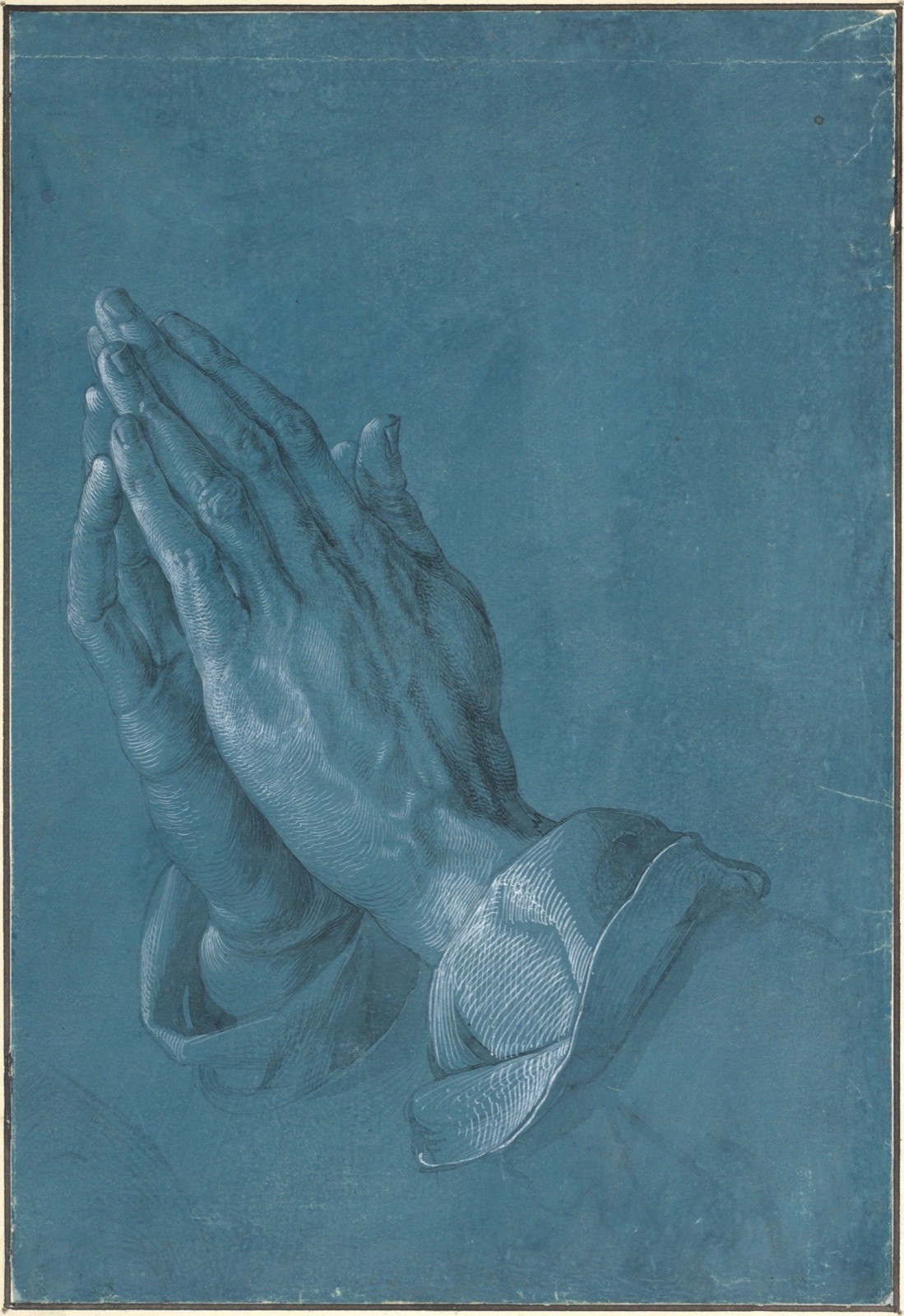 Two hands joined in prayer, modelled in gray wash and white heightening on blue paper