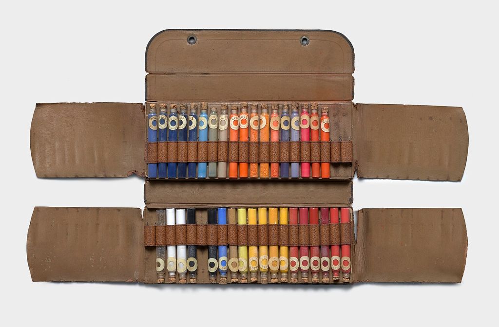 Contextual image of set of powdered pigments in a leather case.
