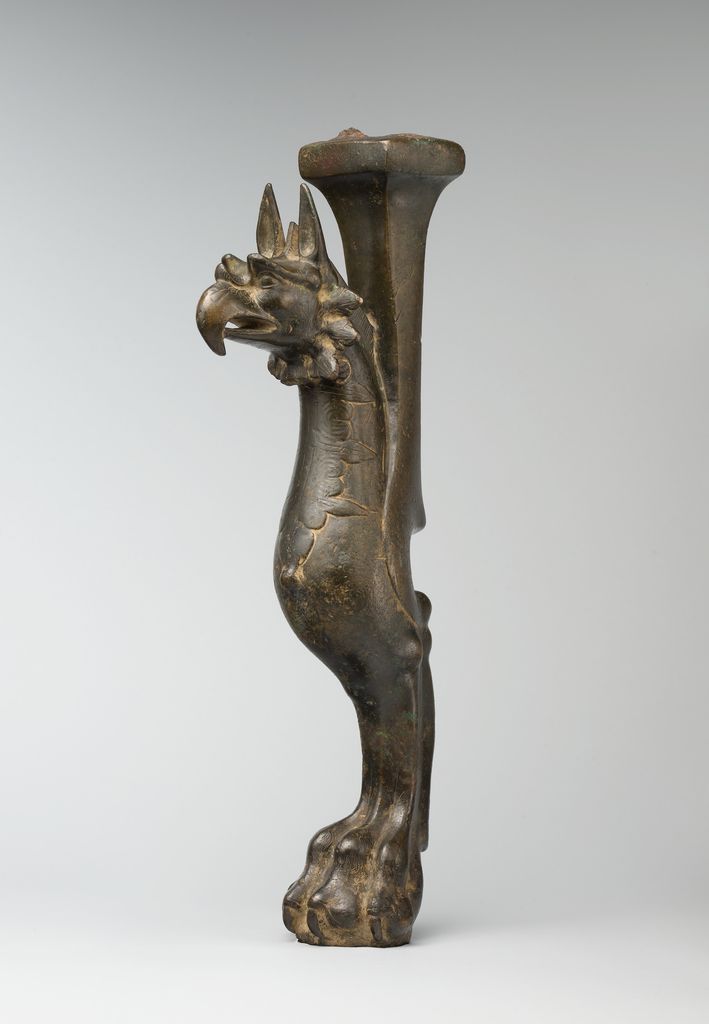 A bronze Iranian throne leg takes the form of a standing winged griffin.